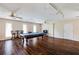 Spacious game room with pool table, ceiling fans, and dark wood flooring is great for entertaining at 5130 N Peachtree Rd, Dunwoody, GA 30338