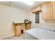 Laundry room with wooden cabinets, laminate countertops, white washer, and dryer at 5130 N Peachtree Rd, Dunwoody, GA 30338