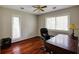 Bright home office featuring hardwood floors, two windows with blinds, ceiling fan, and dark wood desk at 5130 N Peachtree Rd, Dunwoody, GA 30338