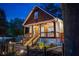 Beautiful home exterior with a covered porch, elegant lighting, landscaped yard, and a brick driveway at 1060 Mcdaniel Sw St, Atlanta, GA 30310
