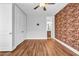 Bedroom with wood floor, exposed brick wall, closet, and door to ensuite bathroom at 267 Castleberry Station Sw Dr, Atlanta, GA 30313