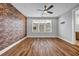This bedroom features an exposed brick wall, wood floors, a large window, and modern ceiling fan at 267 Castleberry Station Sw Dr, Atlanta, GA 30313