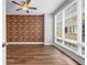 Bedroom with wood floor, exposed brick wall, ceiling fan, and large window with blinds at 267 Castleberry Station Sw Dr, Atlanta, GA 30313