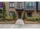 Charming brick townhome featuring a welcoming front door, black window frames, and manicured landscaping at 267 Castleberry Station Sw Dr, Atlanta, GA 30313