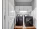 A modern laundry room is conveniently equipped with upper cabinets and sleek, front-load washer and dryer at 267 Castleberry Station Sw Dr, Atlanta, GA 30313