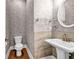 Chic powder room featuring a pedestal sink, decorative mirror, and stylish wall finishes, creating a sophisticated space at 267 Castleberry Station Sw Dr, Atlanta, GA 30313