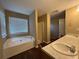 Bright bathroom features a large soaking tub, glass shower, and double sink vanity at 4302 Sorrells Dr, Powder Springs, GA 30127