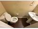 Compact bathroom with a toilet, pedestal sink, and wood-look flooring at 4302 Sorrells Dr, Powder Springs, GA 30127