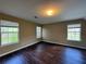 Bright bedroom featuring wood-look floors and three windows at 4302 Sorrells Dr, Powder Springs, GA 30127