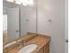 Bathroom featuring granite counters, a mirrored wall, and a white porcelain sink at 602 Abingdon Way, Atlanta, GA 30328