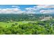 Scenic aerial view of golf course and lush green landscape with city skyline in the distance under a cloudy sky at 8 Collier Nw Rd # B2, Atlanta, GA 30309
