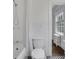 Elegant bathroom featuring a classic toilet, shower with white curtain and black and white patterned tile flooring at 8 Collier Nw Rd # B2, Atlanta, GA 30309
