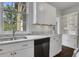 Kitchen showcasing stainless steel dishwasher, sink, marble counters, and white cabinets at 8 Collier Nw Rd # B2, Atlanta, GA 30309