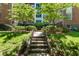 Exterior view of building with lush landscaping, stone steps, and mature trees creating a welcoming entrance at 8 Collier Nw Rd # B2, Atlanta, GA 30309