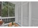 Relaxing screened patio with stylish seating and soft light filtering through the trees and sheer white shutters at 8 Collier Nw Rd # B2, Atlanta, GA 30309