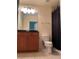 Well lit bathroom with wood vanity and shower with dark shower curtain at 855 Peachtree Ne St # 1912, Atlanta, GA 30308