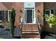 Inviting brick home entrance featuring a stately black door and meticulously landscaped surroundings at 13 Sherman Nw Ln, Cartersville, GA 30121