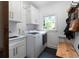 Well-lit laundry room with modern washer and dryer, sink, and storage cabinets at 13 Sherman Nw Ln, Cartersville, GA 30121