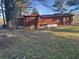 Exterior shot of the home showing the backyard, brown siding, and white painted cinder block foundation at 144 Flat Rock Rd, Oxford, GA 30054
