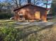 Back exterior with shed, brown siding, a propane tank, and one boarded up window at 144 Flat Rock Rd, Oxford, GA 30054