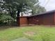 The backyard features brown siding, a red trim, and verdant green grass at 144 Flat Rock Rd, Oxford, GA 30054