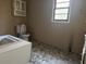 This bathroom includes a standard toilet, a window, and cabinet at 144 Flat Rock Rd, Oxford, GA 30054
