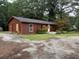 Charming single-story home showcasing painted wood siding and mature landscaping in a tranquil, tree-lined setting at 144 Flat Rock Rd, Oxford, GA 30054