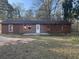 Charming single-story home featuring brown wood siding, a white front door, and orange window trim at 144 Flat Rock Rd, Oxford, GA 30054