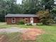 Cozy one story home with a yard featuring mature trees and an exterior with painted wood siding and trim at 144 Flat Rock Rd, Oxford, GA 30054