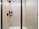 Shower featuring a shower head with included shelf, and a neutral colored, tiled wall at 2540 Ravencliff Dr # 155, Austell, GA 30168