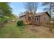 Exterior shot of a cozy home with a brick chimney and a spacious backyard featuring a wooden fence at 3916 S Martin Way, Lithia Springs, GA 30122
