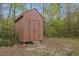 Backyard shed with wood siding and double doors for storage in wooded area at 3916 S Martin Way, Lithia Springs, GA 30122