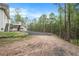 View of yard with parking area and wooded backdrop at 5732 Falls View Dr, Buford, GA 30518