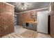 Basement bar area with brick walls, sink, refrigerator, and unique lighting fixture at 5732 Falls View Dr, Buford, GA 30518