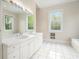 Bathroom with a double vanity, large mirror, tile flooring, and large windows at 5732 Falls View Dr, Buford, GA 30518