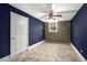 Dark blue bedroom featuring unique stone accent wall, stylish ceiling fan, and a window at 5732 Falls View Dr, Buford, GA 30518