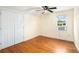 Bedroom with hardwood floors, ceiling fan, closet, and window AC unit at 5732 Falls View Dr, Buford, GA 30518