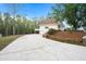 Side view of a yellow house with a driveway, stone wall, and manicured landscaping at 5732 Falls View Dr, Buford, GA 30518