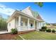 Charming yellow two-story home featuring a manicured lawn, front porch, and unique architectural details at 5732 Falls View Dr, Buford, GA 30518