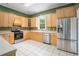 Traditional kitchen with stainless steel appliances, tile floor, and lots of wooden cabinets at 5732 Falls View Dr, Buford, GA 30518