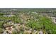 A high angle aerial view shows the two-story home's proximity to the surrounding neighborhood and the woods at 1010 Allenbrook Ln, Roswell, GA 30075