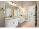 Bright bathroom with a double vanity, granite countertops, and white cabinets at 1010 Allenbrook Ln, Roswell, GA 30075