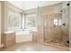 Bright bathroom with a soaking tub next to windows and a separate glass shower at 1010 Allenbrook Ln, Roswell, GA 30075