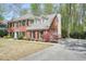 Charming brick home features a well-kept lawn, mature landscaping, and a spacious driveway with a garage at 1010 Allenbrook Ln, Roswell, GA 30075