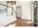Bright foyer with wood floors, a staircase with white risers and a dark wood handrail, and a black front door at 1010 Allenbrook Ln, Roswell, GA 30075