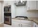 Close-up of a kitchen with a stainless steel oven, microwave, and gas stovetop at 1010 Allenbrook Ln, Roswell, GA 30075