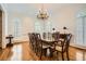 Spacious dining room with a large table, chandelier, hardwood floors, and elegant window shutters at 4503 Payton Oaks Ne Pl, Atlanta, GA 30345