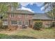 Brick home featuring a stone patio and outdoor dining space perfect for entertaining with a view of the lush backyard at 4503 Payton Oaks Ne Pl, Atlanta, GA 30345