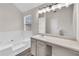 Bright bathroom featuring a large vanity, tub and window at 4720 Buffalo St, Fairburn, GA 30213