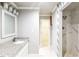 Bathroom features granite countertop, modern fixtures, and a walk-in shower with marble-look tiles at 4820 Camden Sw Dr, Conyers, GA 30094